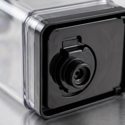 A detailed macro close-up of the plastic connector assembly on the bottom of the Keurig K-2500 water reservoir.