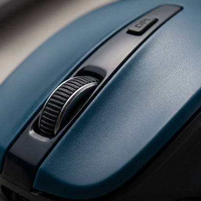 A detailed macro photograph highlighting the metal scroll wheel and DPI button on the dark teal Verbatim Silent Ergo mouse, showing premium materials and texture.