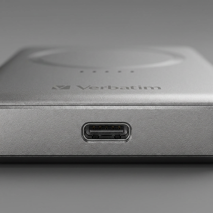 A detailed macro photograph of the Verbatim power bank, focusing on the precise texture of its grey metal casing and the internal quality of its USB-C charging port.