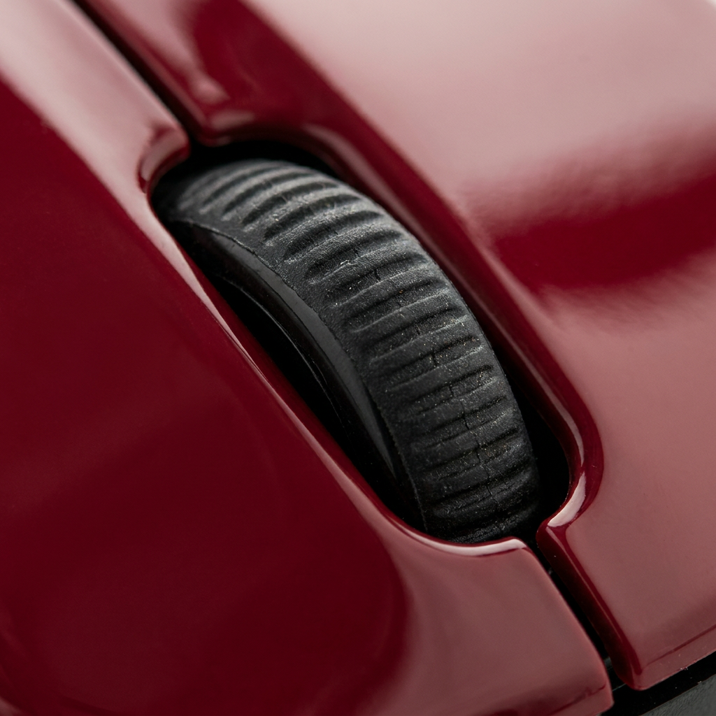 A close-up macro photograph showing the textured rubber scroll wheel and the glossy red plastic surface of the Verbatim Bluetooth mouse.