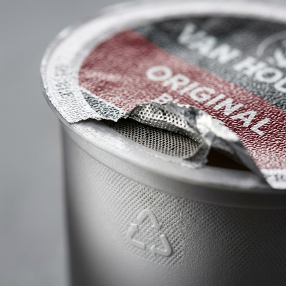 Macro photo detailing the recyclable foil and mesh of a K-Cup pod with "Original" visible.