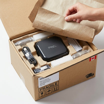 Brother P-touch CUBE Plus label maker securely packed in a shipping box with protective inserts.