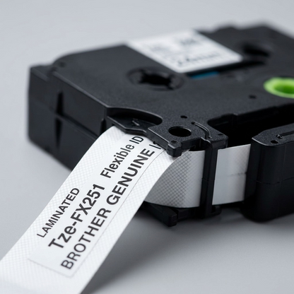 Macro detail of Brother TZe-FX251 Flexible ID Tape cassette showing black on white laminated tape.
