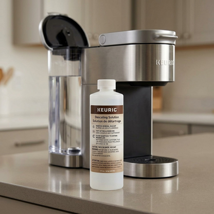 A photograph of the KEURIG Descaling Solution bottle next to a Keurig coffee maker, with water reservoir being filled.