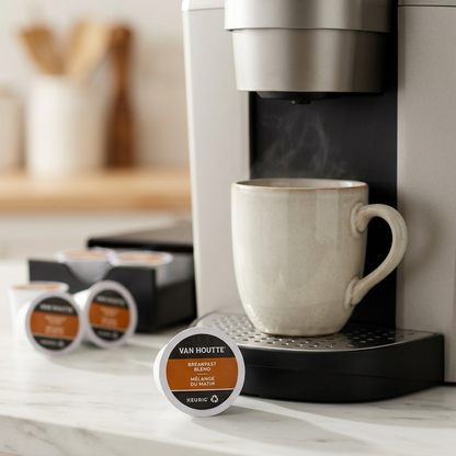 A single Van Houtte Breakfast Blend K-Cup sits beside a steaming mug in a modern Keurig brewer.